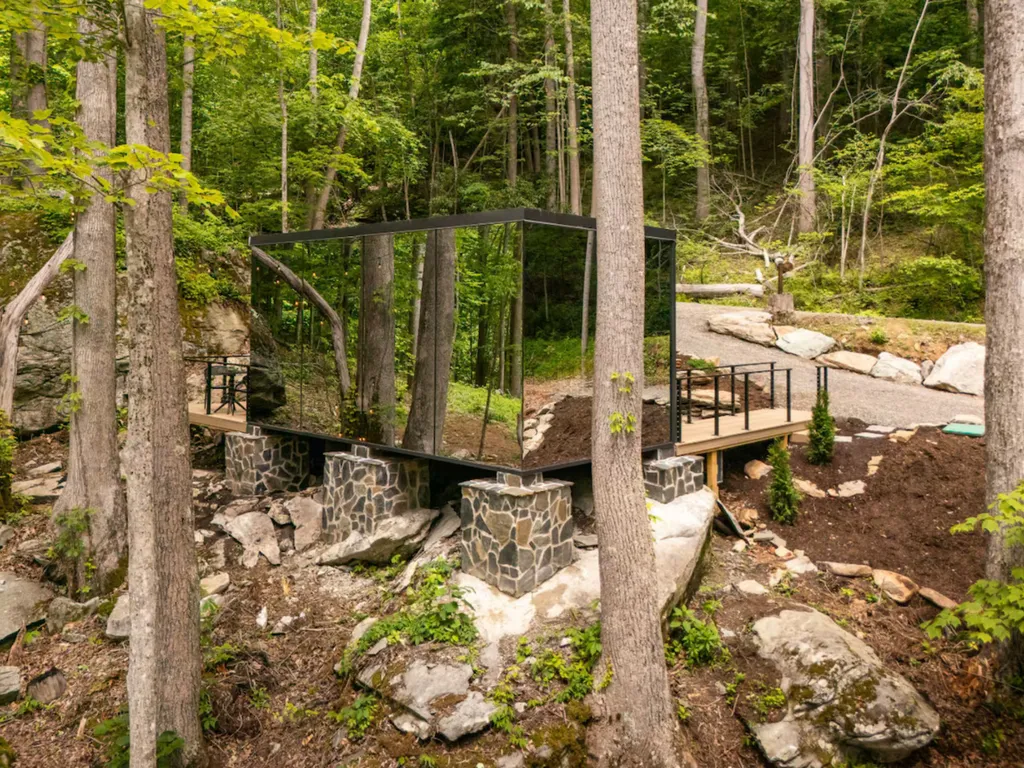 Cabina con esterno a specchi circondata dalla natura