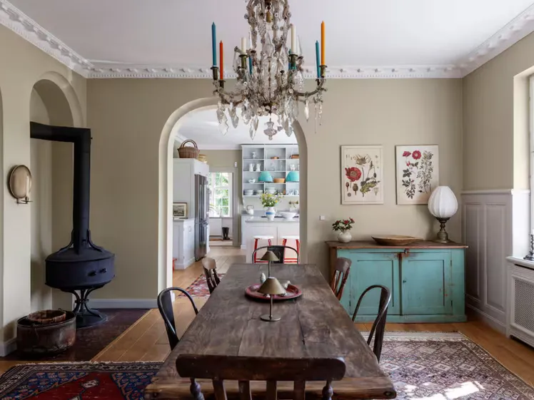 Tavolo da pranzo elegante in una sala con carta da parati stampata e candele colorate