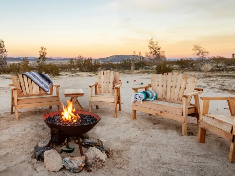 Fuoco da campo con vista sulle montagne rocciose del deserto al tramonto