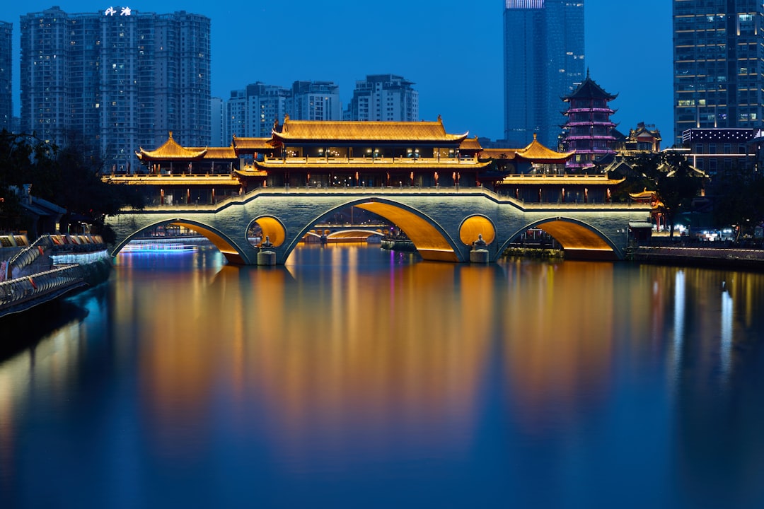 A bridge over a body of water with buildings in the background